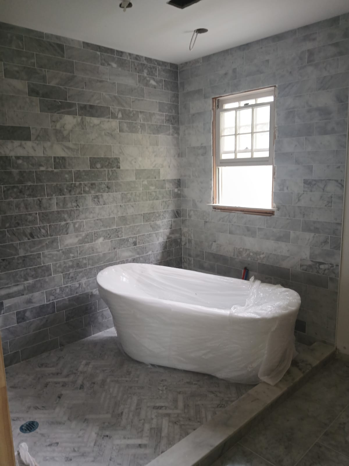 Gray marble bathroom with freestanding tub